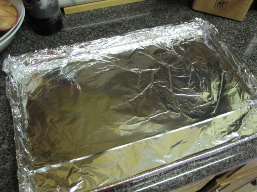 Carefully line the jelly roll pan with aluminum foil, folding out the excess in the corners.  Lining the pan makes a huge difference when it is time to remove the candy.