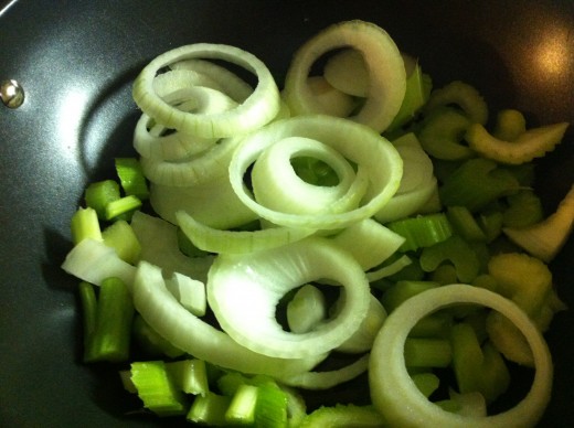 Celery and onions are in the wok cooking