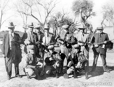  The police officers who aided in the capture of the Dillinger gang in Tucson Arizona shown above with five sub-machine guns, bullet proof vests, revolvers and ammunition taken from members of the gang of Bank Robbers and escaped convicts. From left 