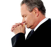 a business man praying for more wealth