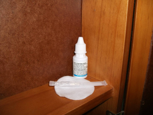 Eye drops for keeping the eyes hydrated, and a cotton pad.
