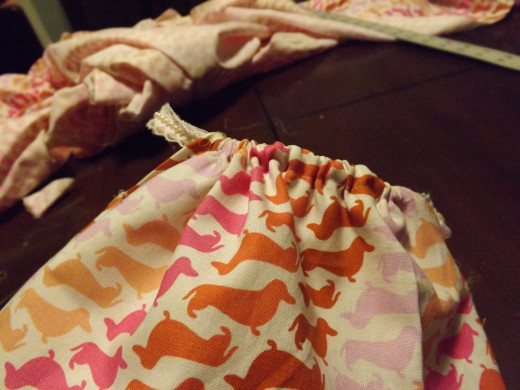 Once the ribbon is all the way through the casing, gently gather the fabric on it.