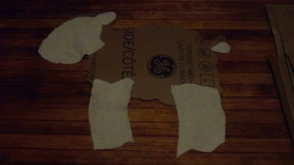 Cut out cardboard form of lamb (or whatever animal you want) and fabric to cover parts that aren't wooly.  In retrospect I realized I should have painted the cardboard white so there would be no visible bald spots with cotton balls.