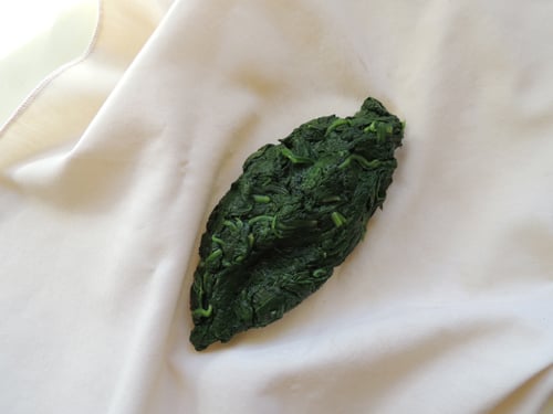 place steamed spinach on clean linen cloth