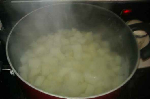 Start by peeling and cubing the potatoes. Boil the potatoes in a large pot barely covered with water.