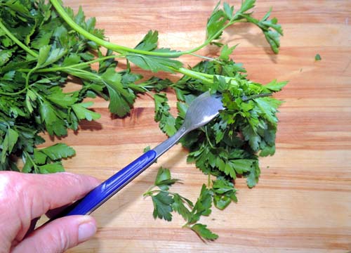 grasp parsley firmly by stems, and rake fork through leaves