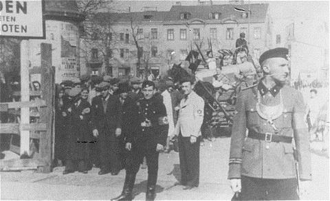 This picture includes both German and Jewish police guard an entrance to the Łódź Ghetto.  