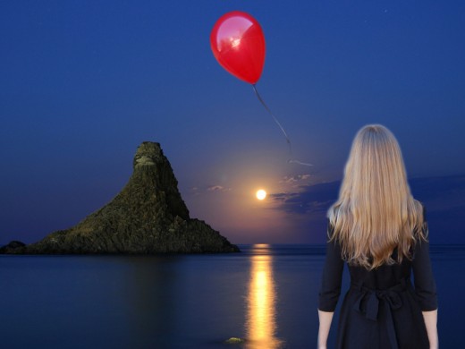 Find your own unique way to let go of the bad feelings after divorce. This photo shows a woman releasing a red balloon over the ocean at sunset.