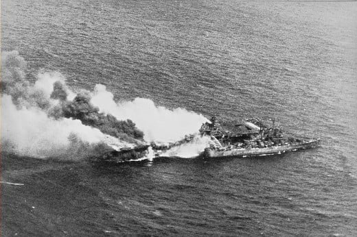 The USS Pittsburgh comes alongside the burning carrier to fight the fires and assist in any way it can Source: Wikipedia (Public Domain)