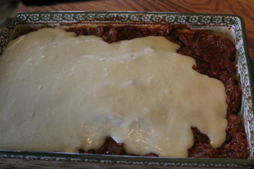 Spreading Bechamel over Meat Sauce 