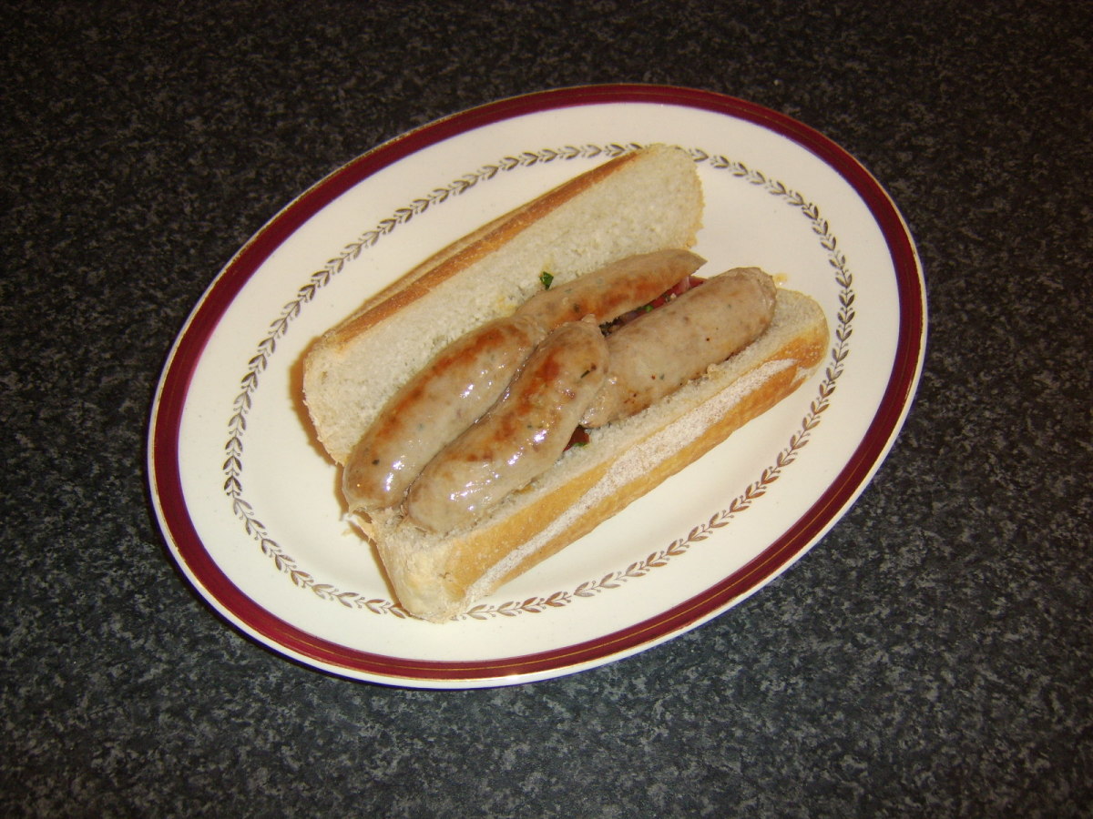 Halved pork sausages are laid on top of vegetables