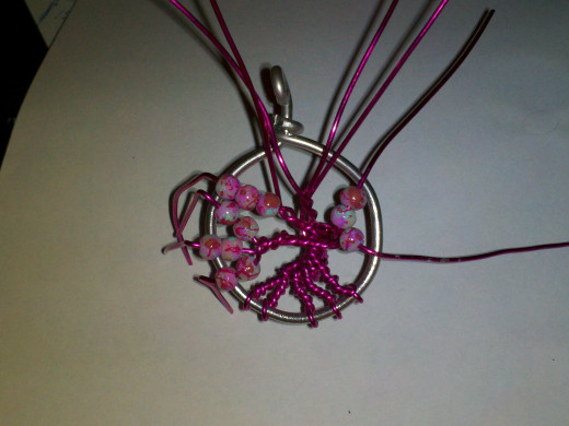 Rearrange limbs and twist a couple together from different groups. Thread beads and bend over frame to keep from sliding off wire.
