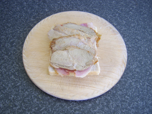 Turkey slices are placed on top of the bacon