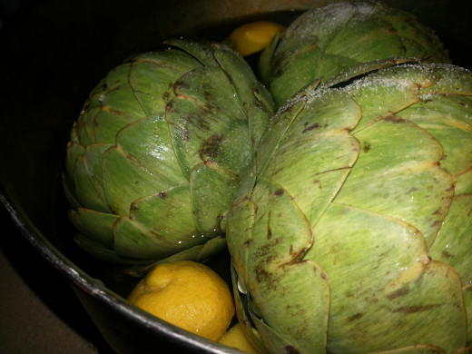 Put the artichokes, stems and lemon wedges in the pot of water.