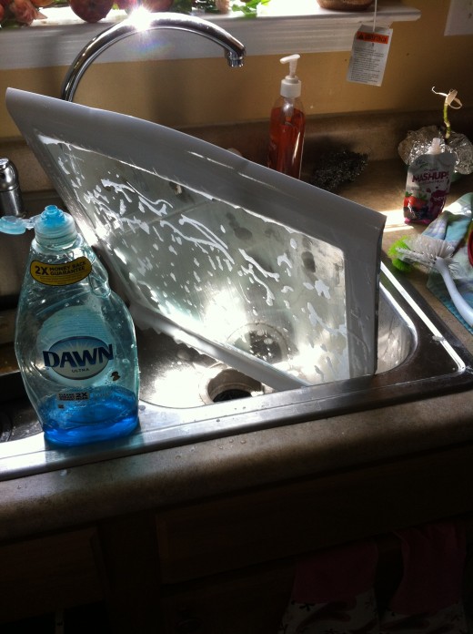 Washing the top shelf with dishwashing liquid soap, then with glass cleaner.