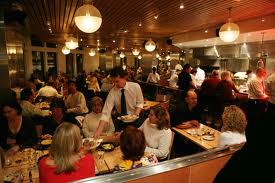 It is a very humid Friday night in late June 2012 in a bar/restaurant in the East Village. There is a mixture of people including bored Upper East Side rich people, unfettered college students, bored suburban housewives, and blue collar men.