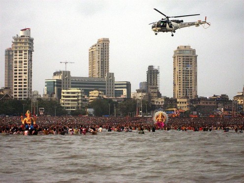 An Indian Cost Guaard Helicopter patrols a Ganesh Visarjan ritual at Chowpatty Beach, Mumabi