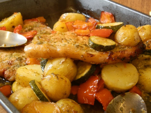 lemon pork chops and roasted vegetables in oven dish