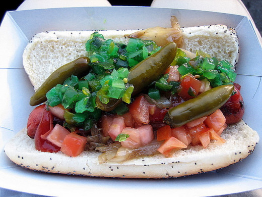 Loaded hot dog with pickles, tomatoes, more!