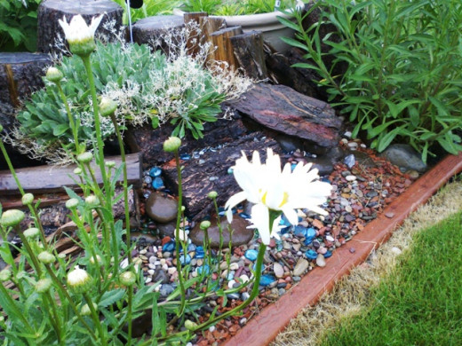 This raised bed was made from rocks, pebbles, pieces of wood, and a few glass beads.