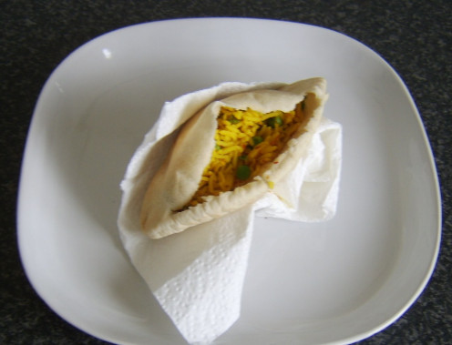Indian spiced rice is spooned in to a pitta bread pocket