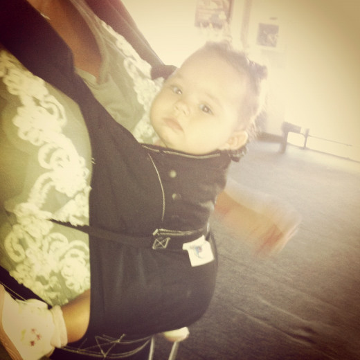 Ergo Baby Carrier, wearable in 3 positions & comes with a sleep hood.  Perfect for airplane travel.