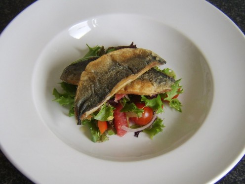 Crispy skinned fried herring fillets are served on a bed of red grapefruit salad