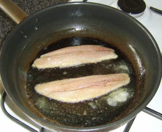 herring fillets are added to the frying pan skin sides down