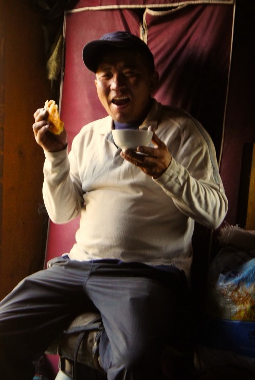 After a long day's at the wheel, our driver, Bagi, enjoys a bowl of warm yak's milk and a chunk of delicous nomad bread 