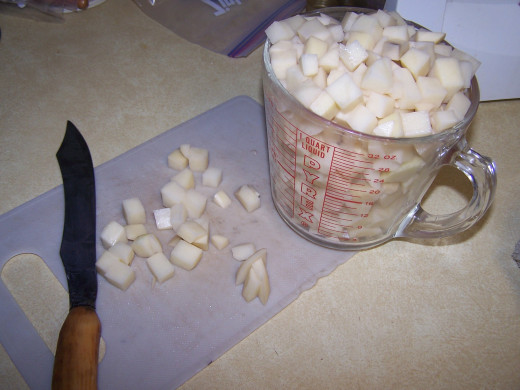 This illustration shows four cups of diced potatoes ready to be added to the stock pot.