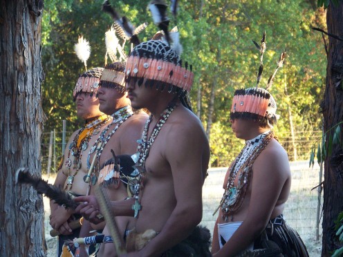 Pomo dancers in cultural attire.