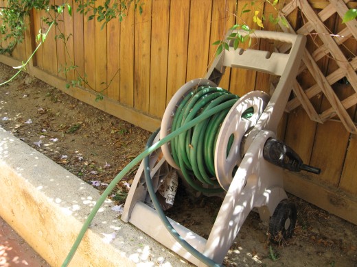 Rubber garden hose in its wheel house storage.