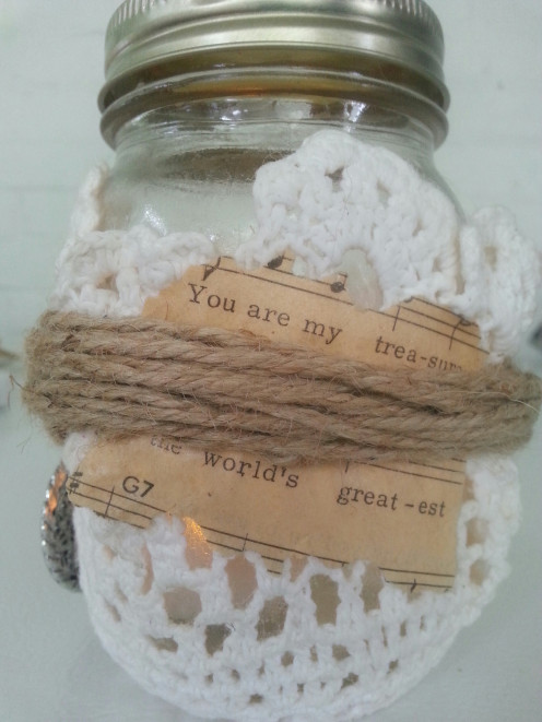 Tear sheet music to include select lyrics and apply on top of doily with Mod Podge and allow to dry. Wrap with jute twine and secure with a knot.