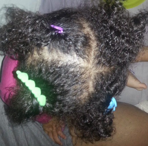 Hair in 4 section parts with barrettes as hair clips.