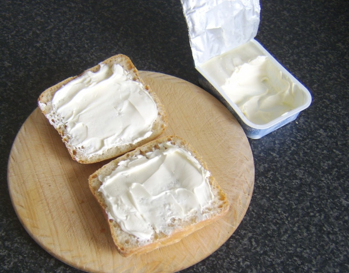 Cream cheese is spread on pain rustica