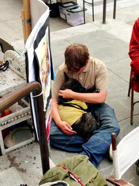 A tired protester embraces the Mailman's best friend.