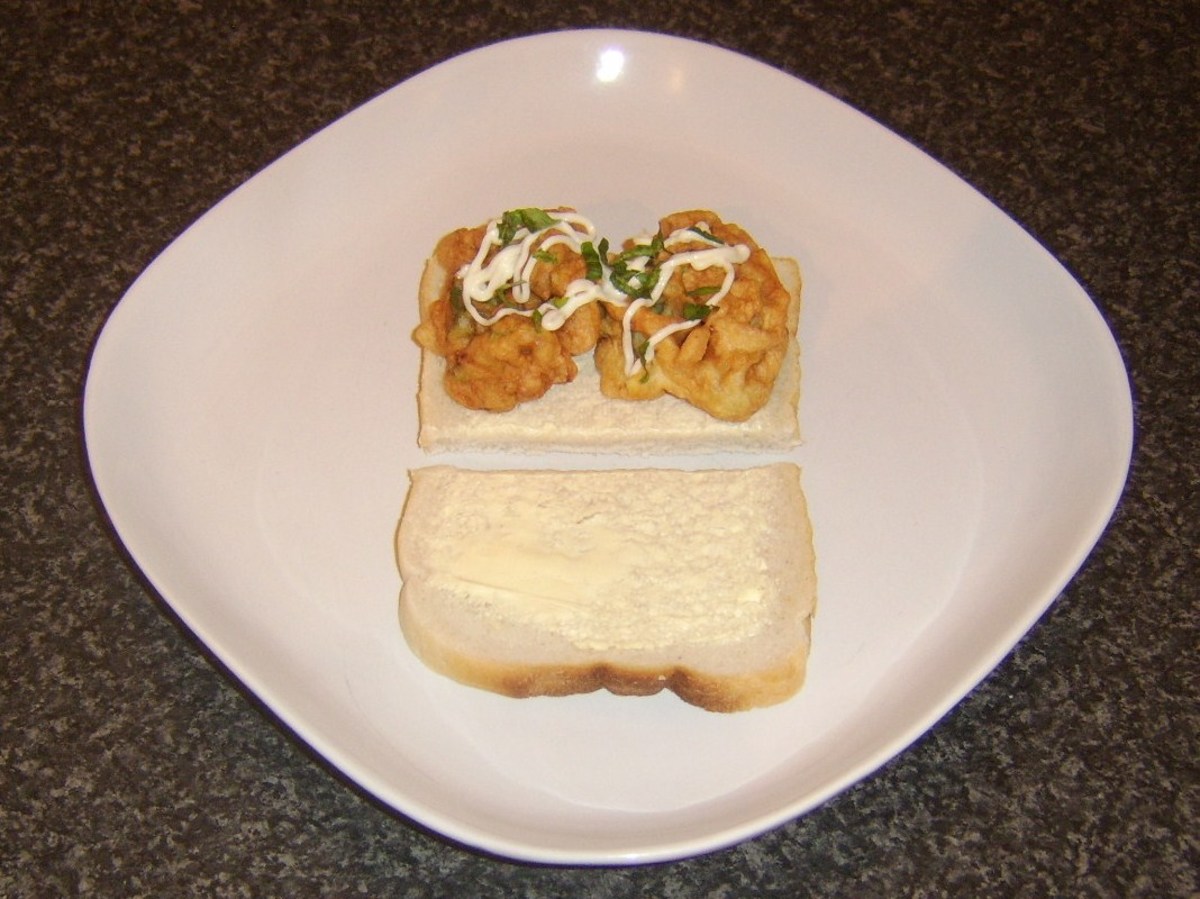 Bell pepper fritters are added to bread, drizzled with mayo and garnished with basil