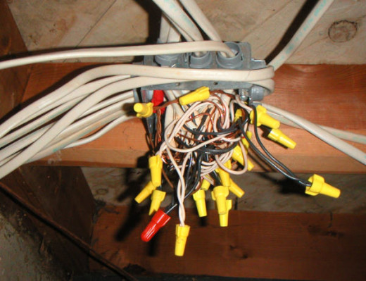 A severe overcrowded junction box which is unsafe and a code violation.