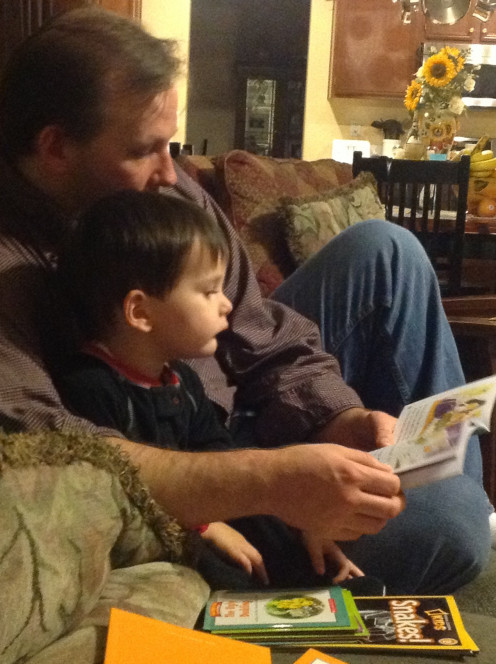 Exhausted father still makes time for reading before bedtime.