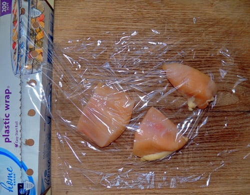 lay plastic wrap flat, place chicken breasts, cover with 2nd sheet of plastic wrap