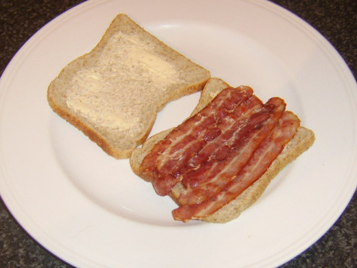 Bacon is laid on one slice of bread