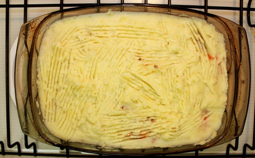 Meat spread evenly in the dish, topped with mashed potato the ruffled with a fork