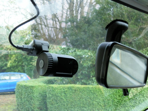 Mini DVR 0801 dashcam situated behind rearview mirror