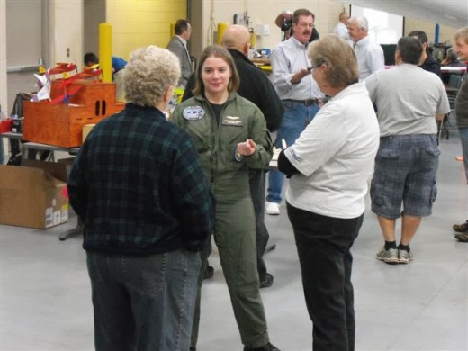 Anna Koerber, a 17 year old aviator, speaking with some attendees. Anna has accomplished flight of the T-6, the L-39, the Piper Warrior, and other aircraft and is ready for her career in aviation.