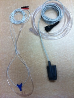 Both upper respiratory sensors seen to the left are placed near, and just inside nostrils to collect information from inspired and expired air. Oximeter, seen right is placed on the finger to collect blood oxygen information. 