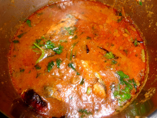 Spicy fish curry is garnished with coriander leaves and ready to eat