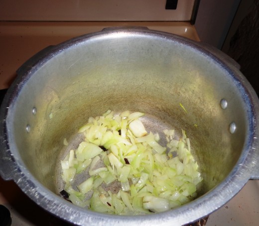 Onions are added inside the cooker for frying along with the ingredients