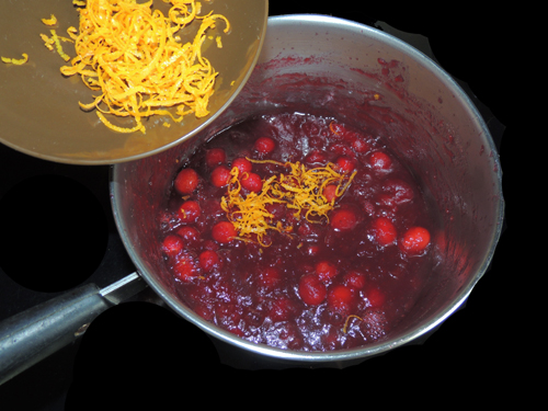 add orange zest to simmering cranberries, reserving a bit for garnish