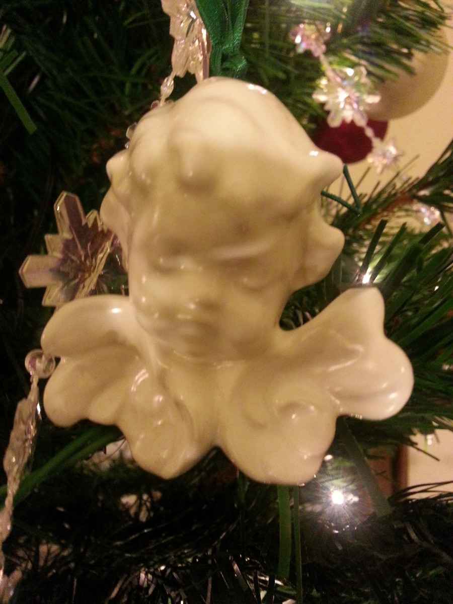 Ceramic angel head made by a co-worker.  This one is really beautiful and hangs from a green satin ribbon.  I like to place it near the top of my tree, as it looks like she is looking down at us.