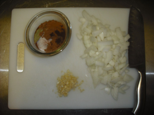 Meanwhile, prepare your remaining ingredients by chopping the onion and garlic, then pre-measuring all of the spices.